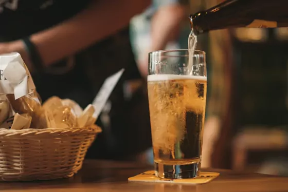 Čepované pivo se pění ve sklenici na baru